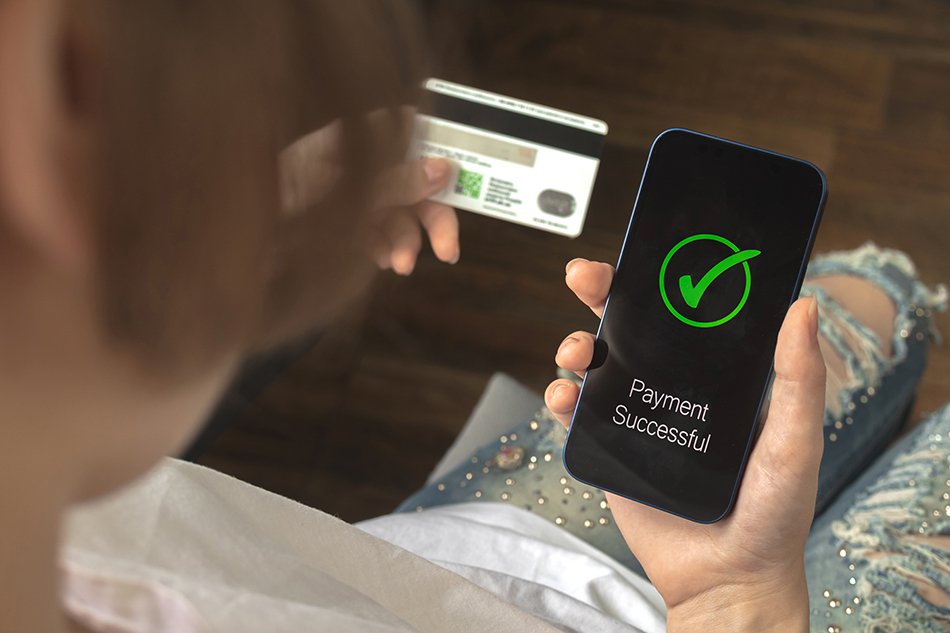 Financial transaction. Woman using mobile phone and hold credit card. Payment successful screen, shopping and e-commerce concept